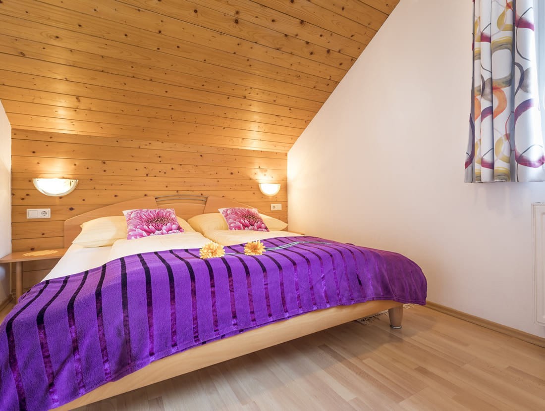Schlafzimmer mit Doppelbett in der gemütlichen Mansarde