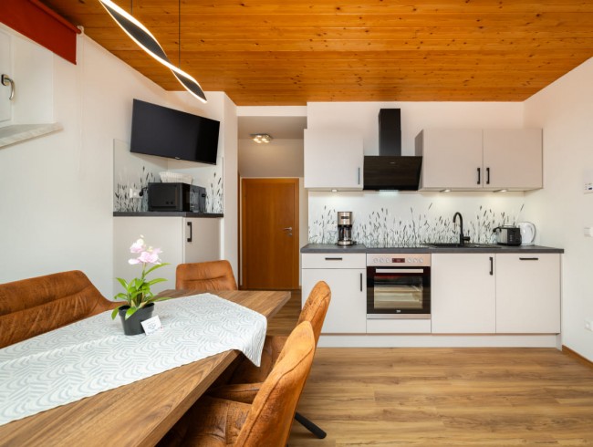 Wohnküche mit Esstisch und Flat-TV